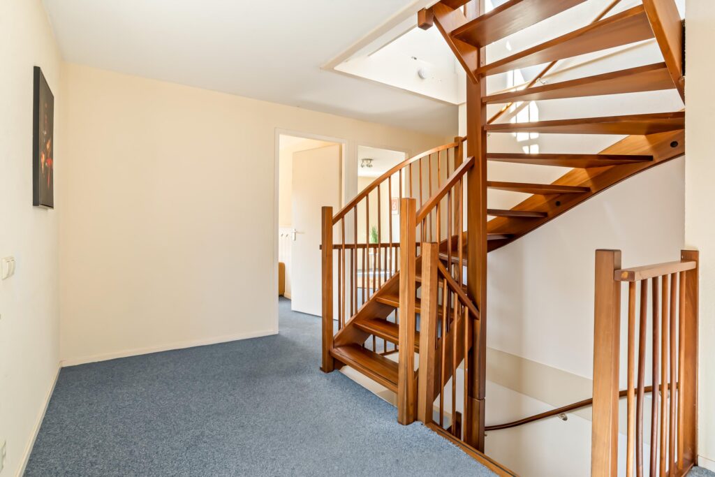 Wooden spiral staircase in bright hallway