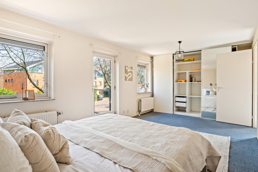 Bright minimalist bedroom with large windows and storage.