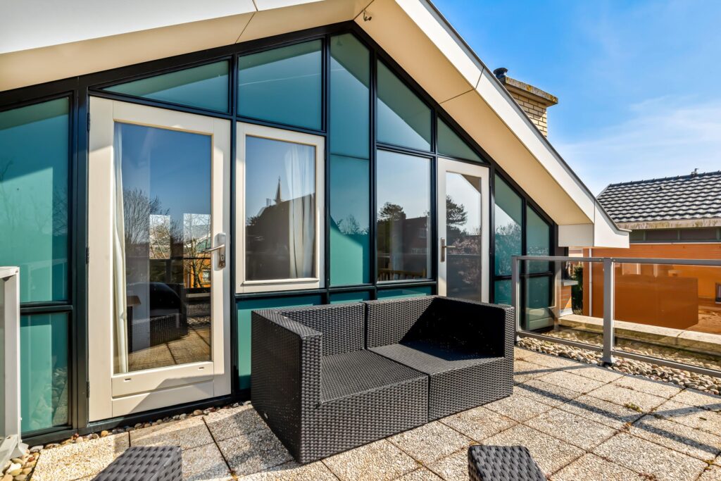 Modern rooftop patio with glass doors and seating