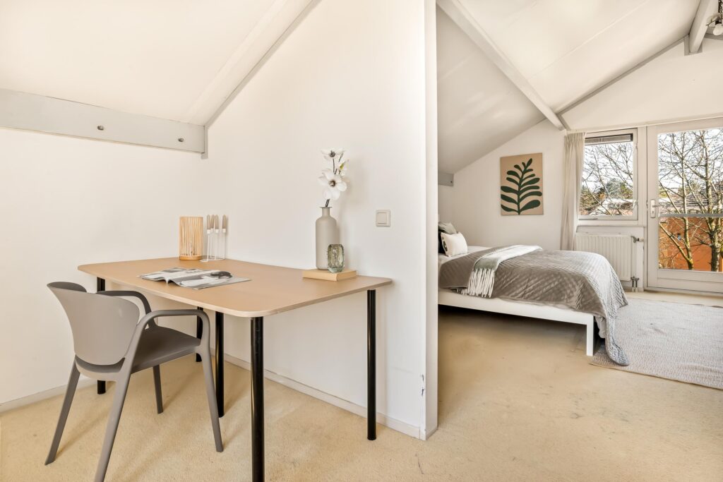 Cozy attic bedroom with desk and chair.