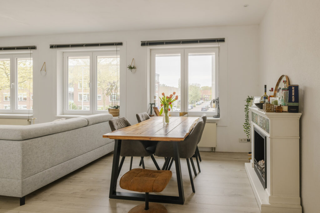Bright dining room with large windows and fireplace.