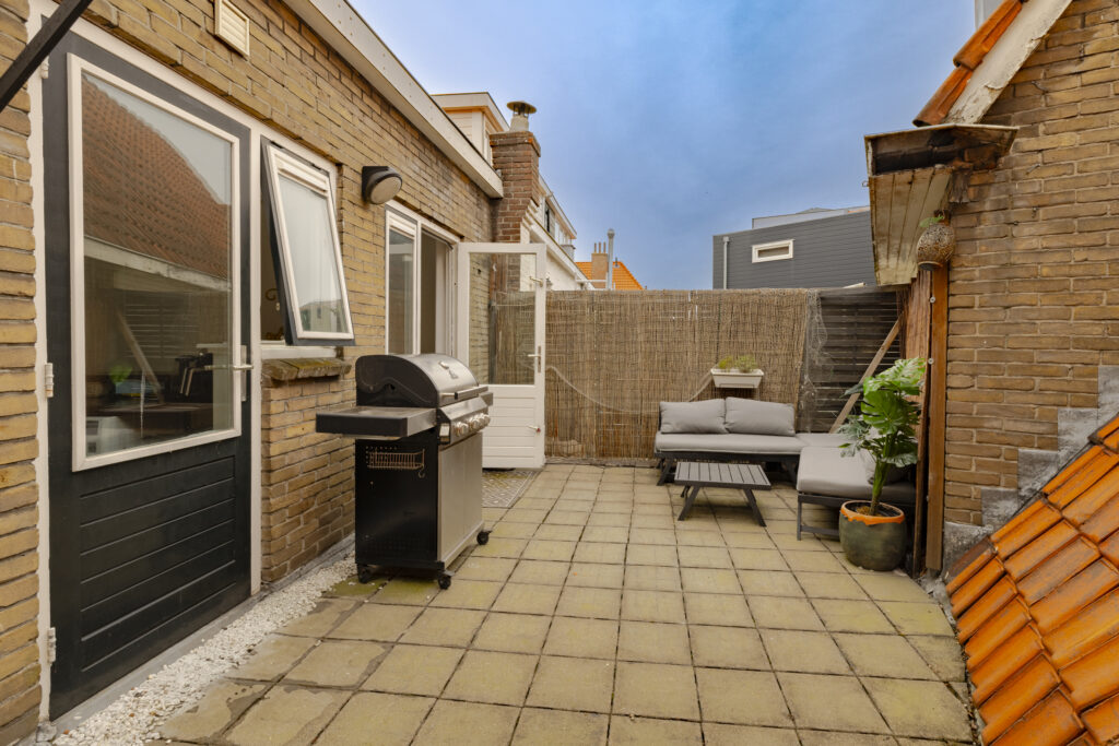 Cozy patio with grill and seating area.