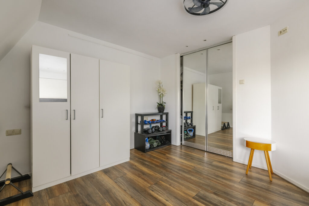 Minimalist room with exercise equipment and mirror closet.