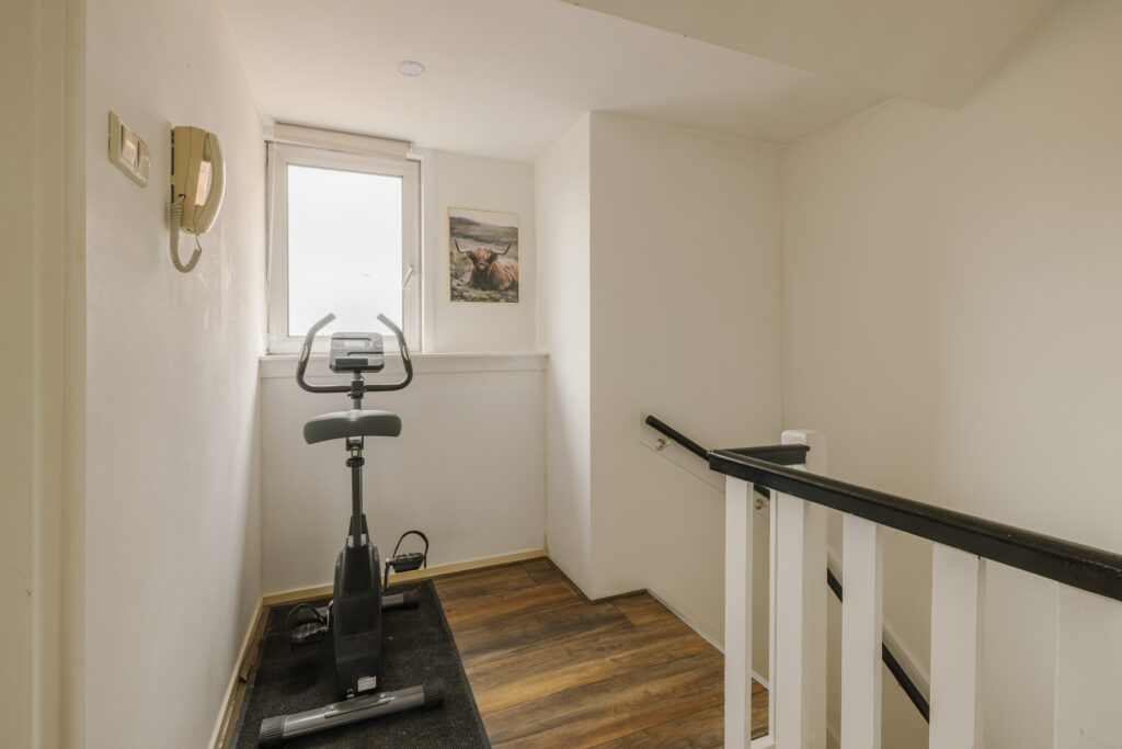 Exercise bike in small, bright hallway space.