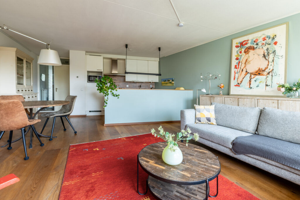 Modern living room with kitchen and vibrant decor.