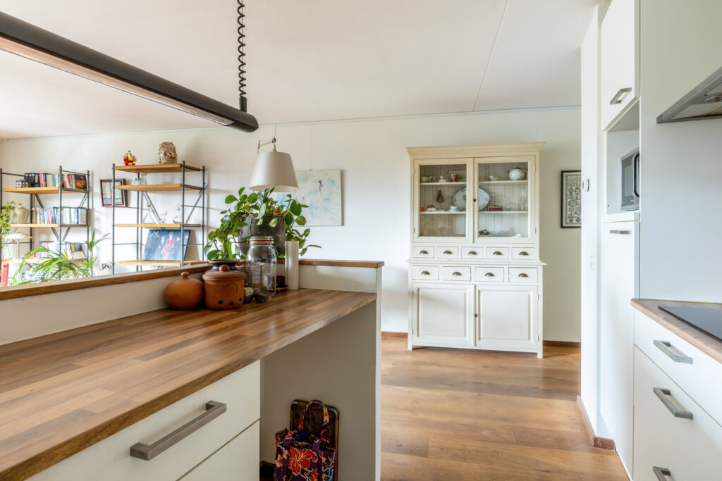 Modern kitchen with wooden countertops and white cabinets.