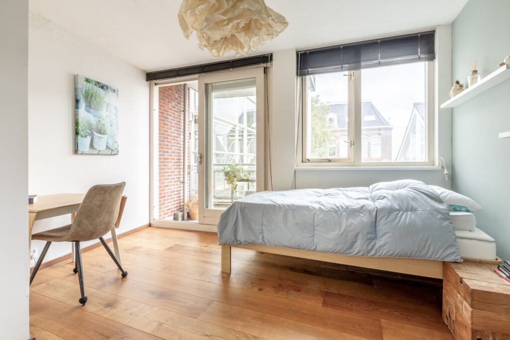Bright bedroom with bed and wooden floor