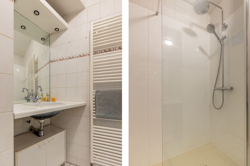 Bathroom with sink, mirror, and walk-in shower.