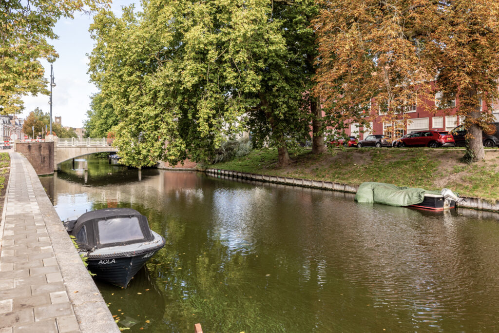 Scenic canal with boats and bridge in autumn.