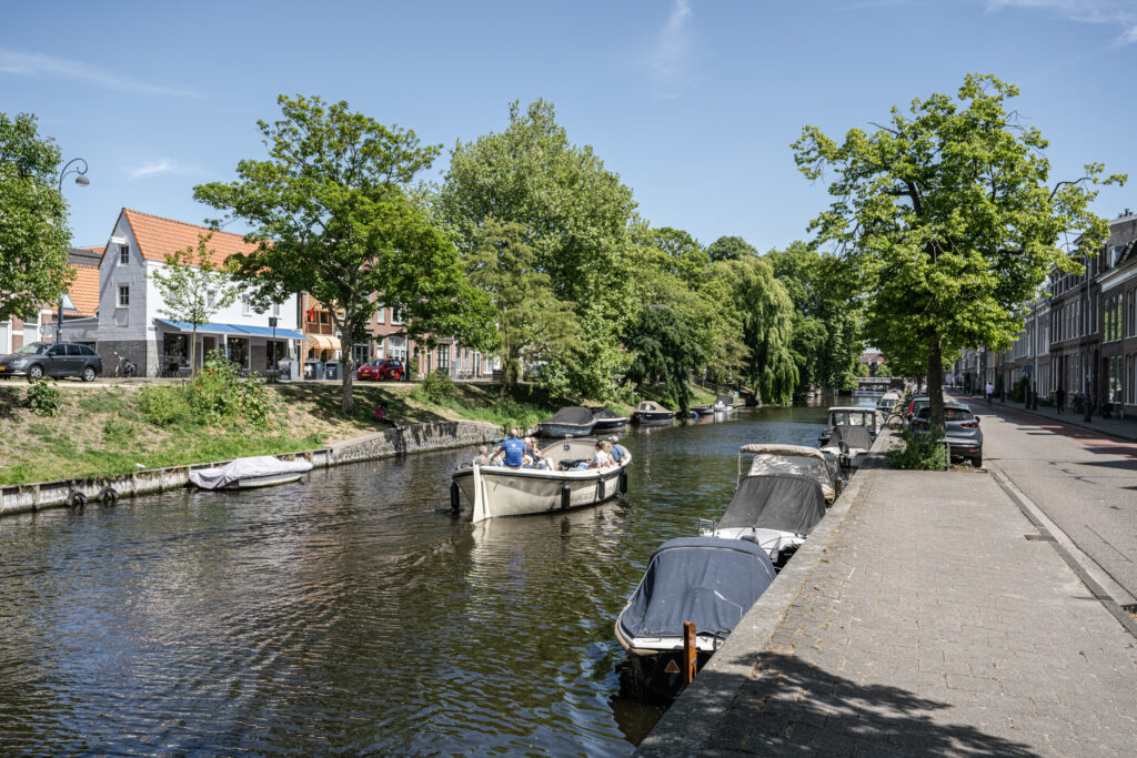 Boats and trees along a peaceful canal scene.