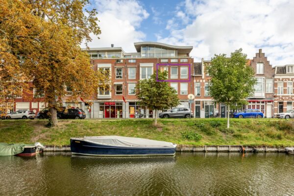 Canal view with boats and autumn trees.