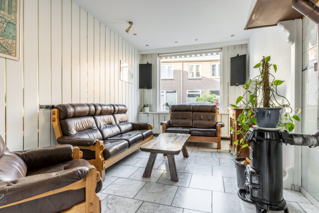Cozy living room with leather sofas and wood stove.