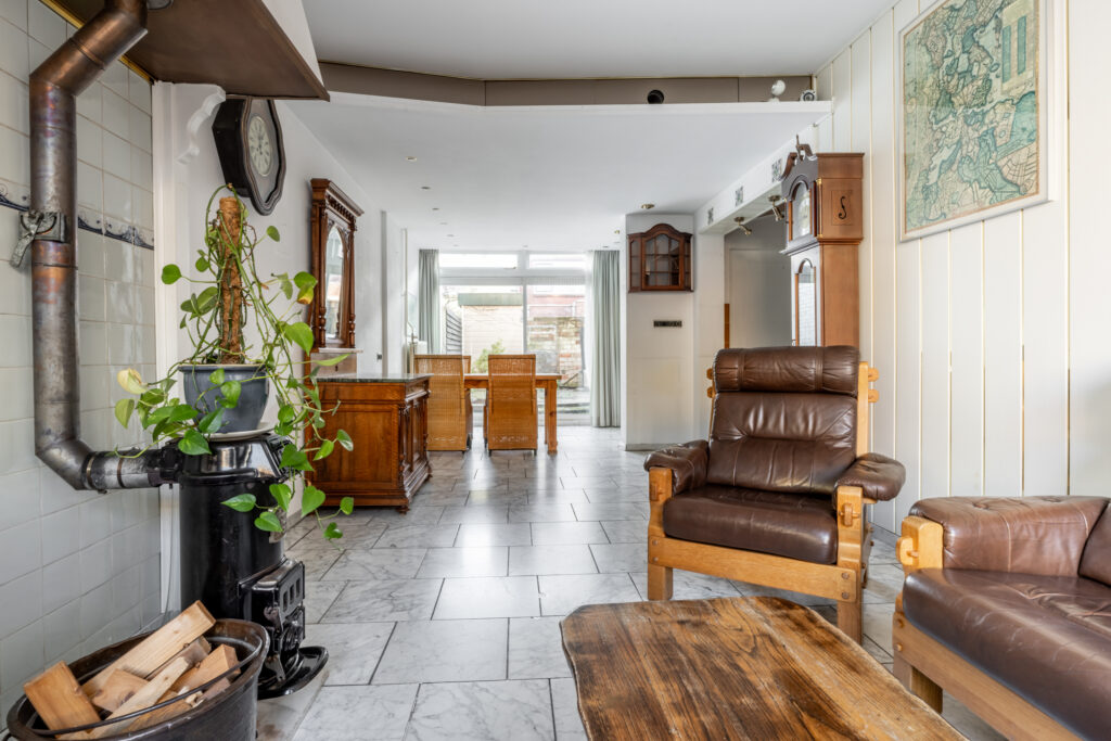 Cozy living room with stove and leather chairs.