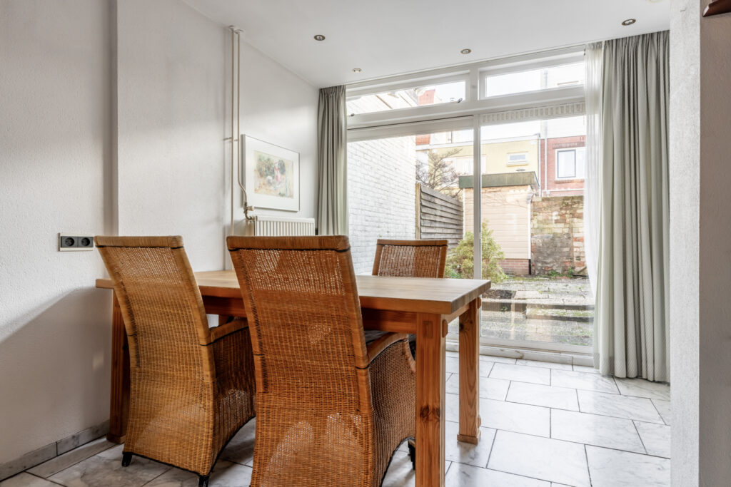 Bright dining room with wicker chairs and garden view.