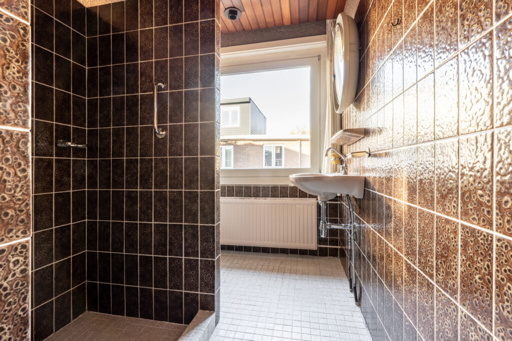 Modern bathroom with tiled walls and sink.