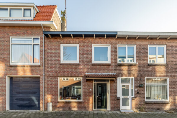 Two-story brick house with large windows and door.