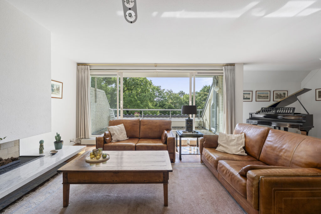 Cozy living room with leather sofas and piano.