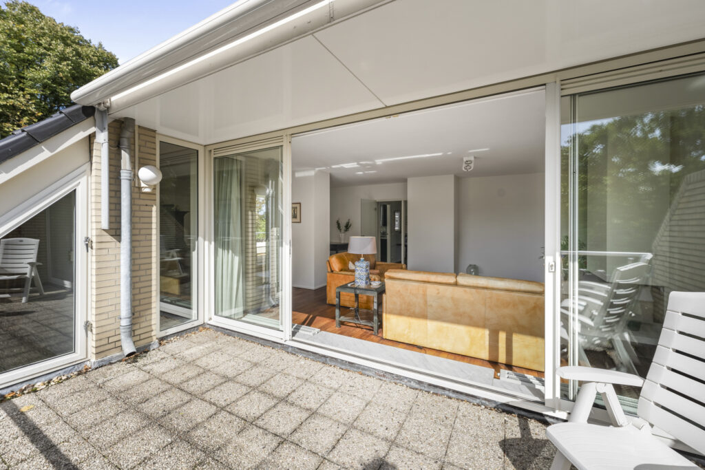Sunny patio leading to cozy living room interior