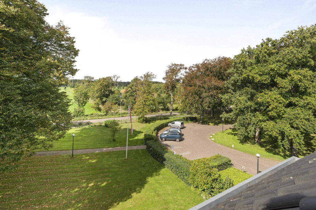 Aerial view of parking lot and green landscape.