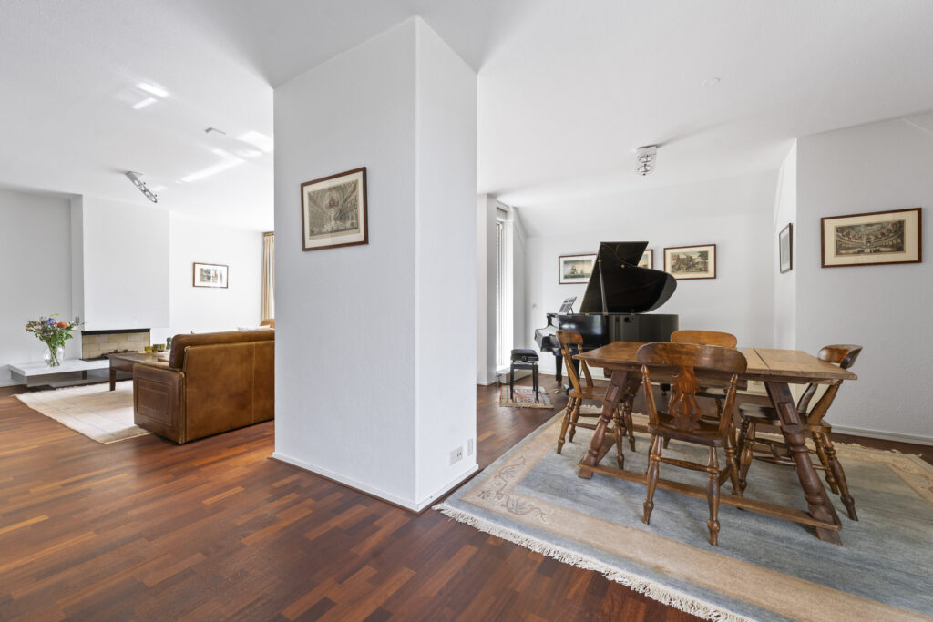 Spacious living room with piano and dining area.