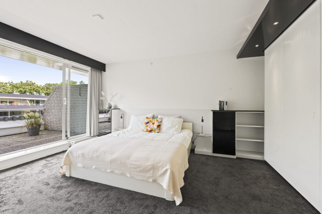 Modern bedroom with large window and bed