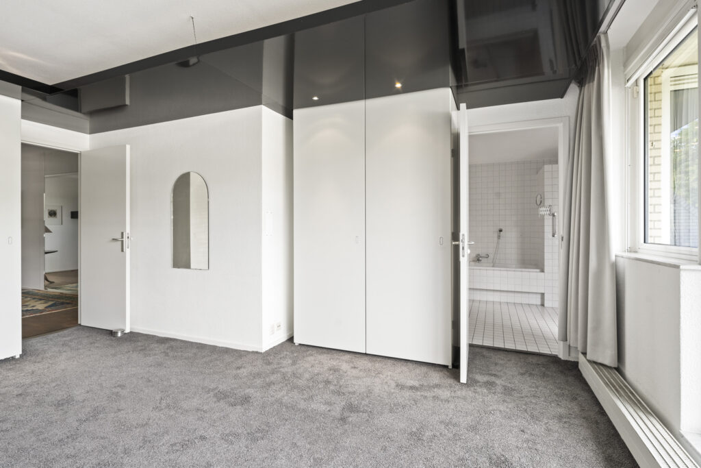Modern room with carpet and open closet doors