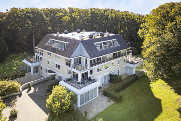 Spacious residential building surrounded by trees and greenery.