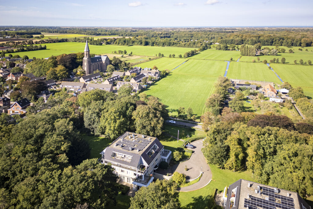Aerial view of village, church, and fields.
