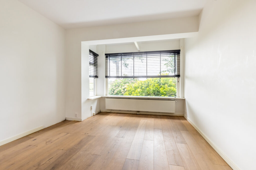 Empty room with wooden floor and large window