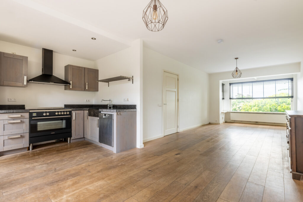Spacious kitchen and dining area with wooden floors.