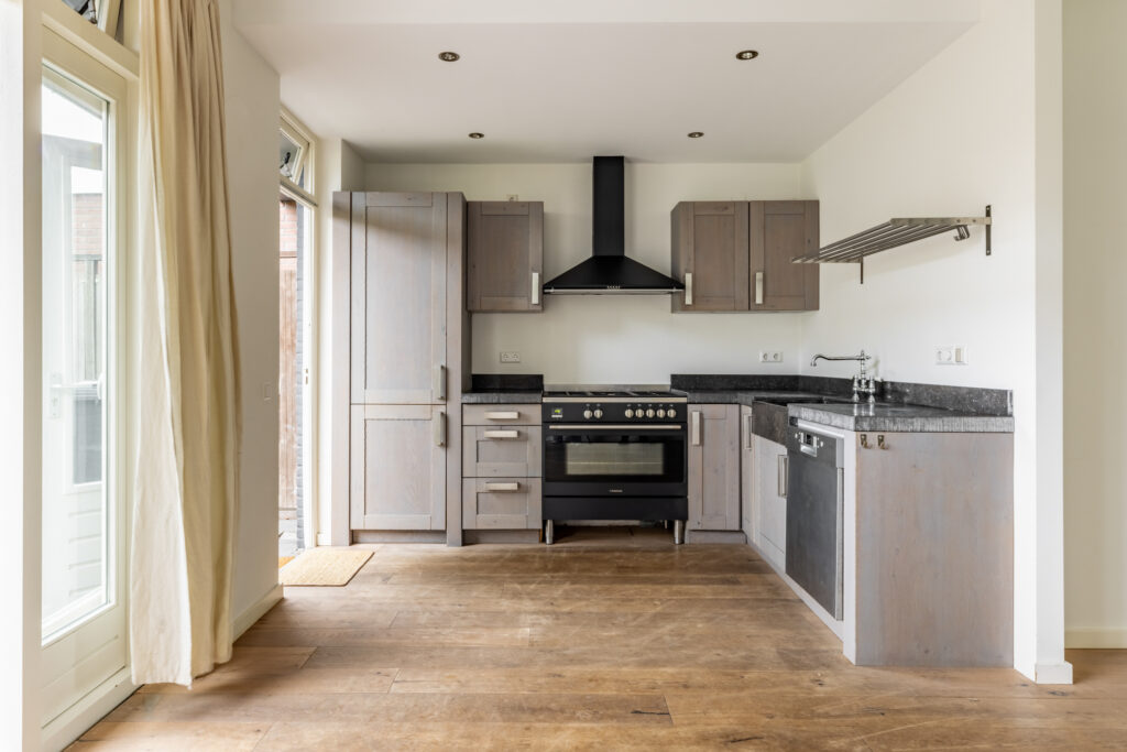 Spacious modern kitchen with wooden flooring.