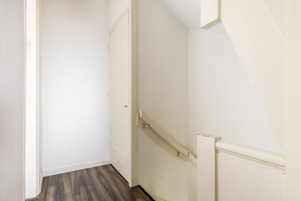 Wooden staircase and white hallway interior