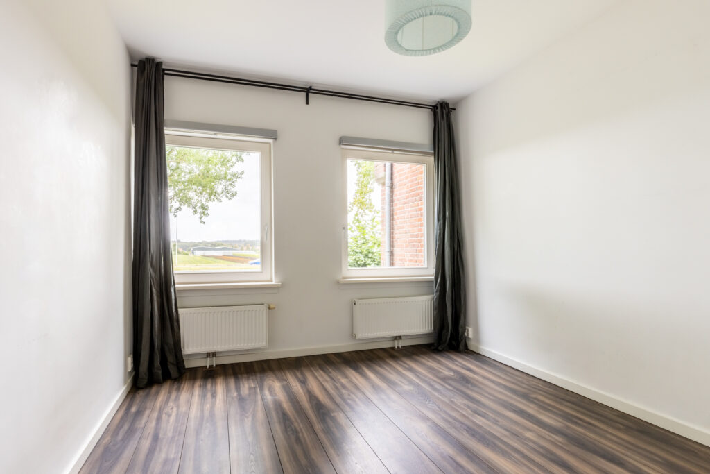 Empty room with windows and wood floor