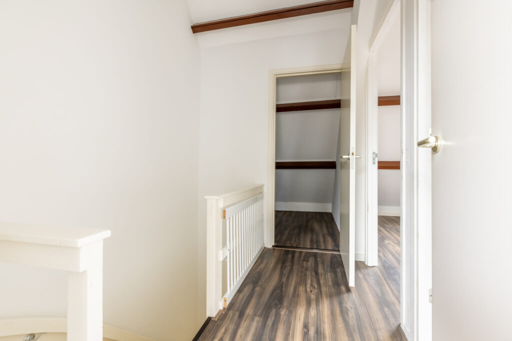 Empty hallway with wooden floor and open doors