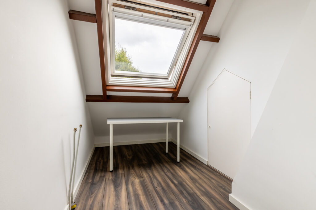 Small attic room with skylight and table.