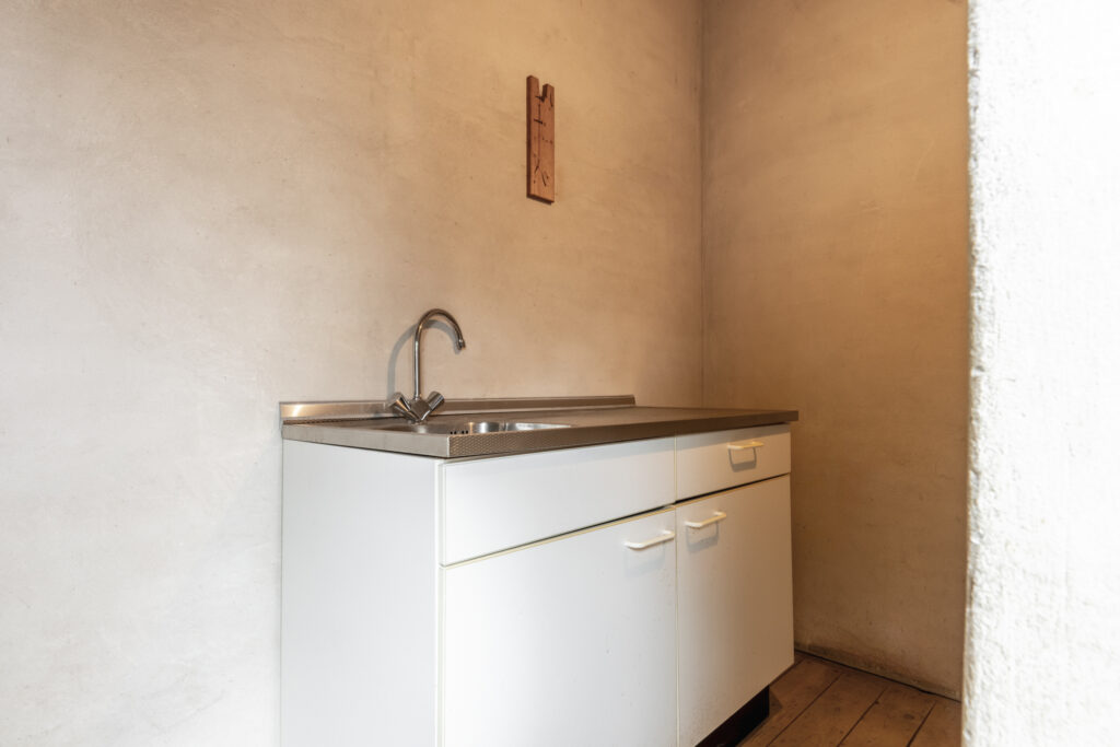 Minimalist kitchen corner with white cabinets and sink