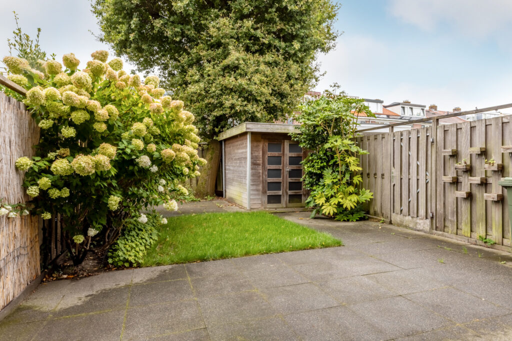 Backyard with shed, flowers, and wooden fence