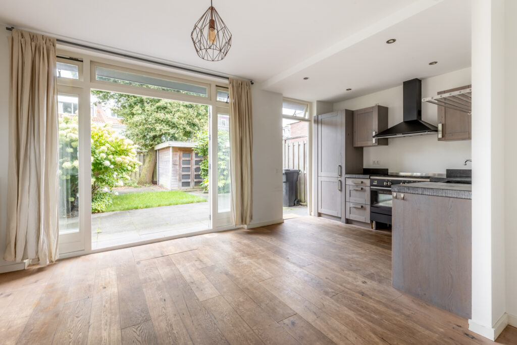 Bright kitchen with wooden floor and backyard view