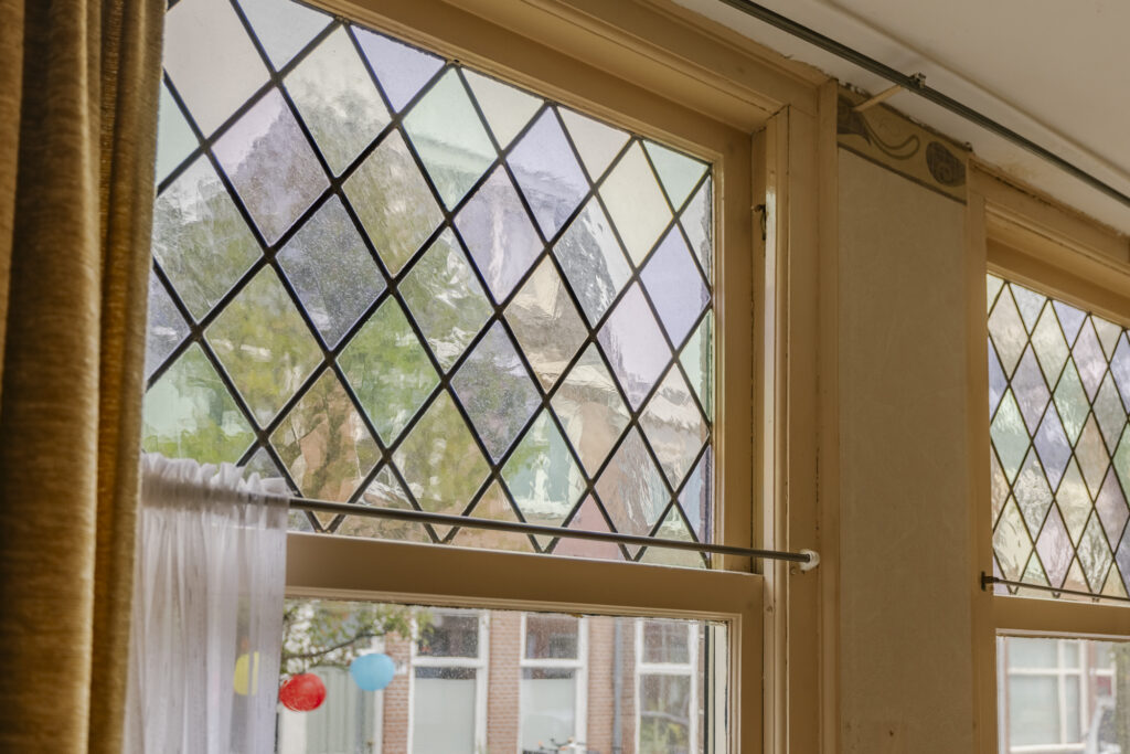 Diamond-patterned window with outdoor view.