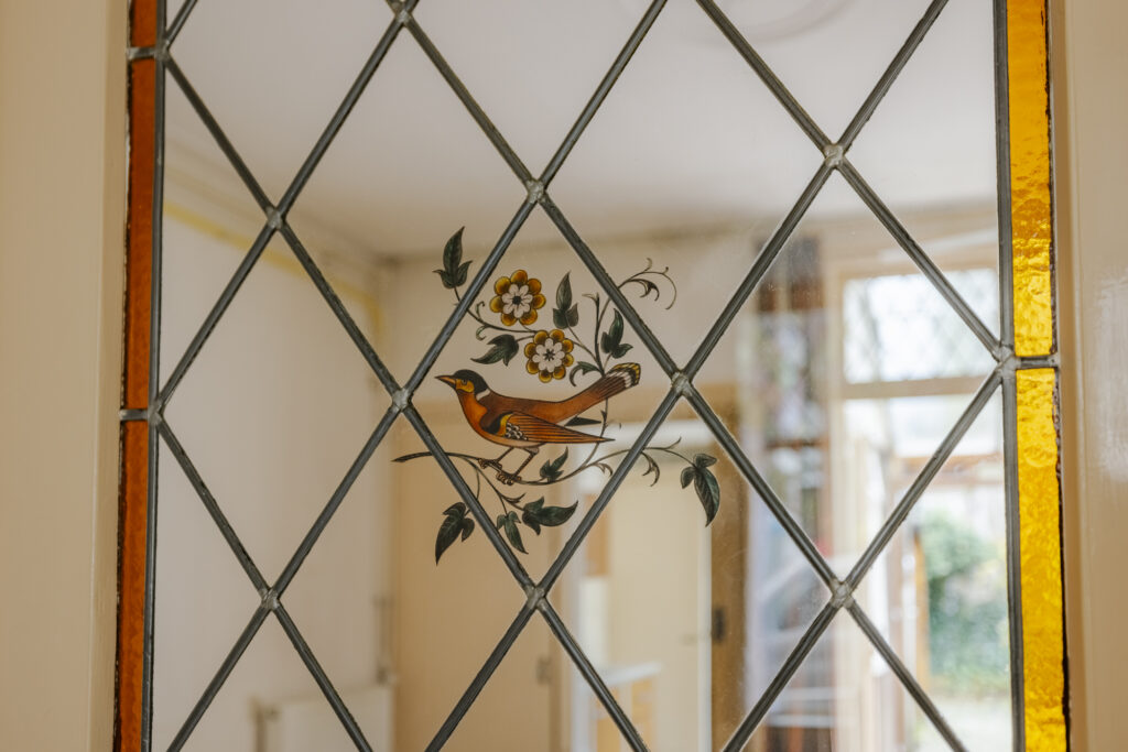 Stained glass window with bird and flowers design.