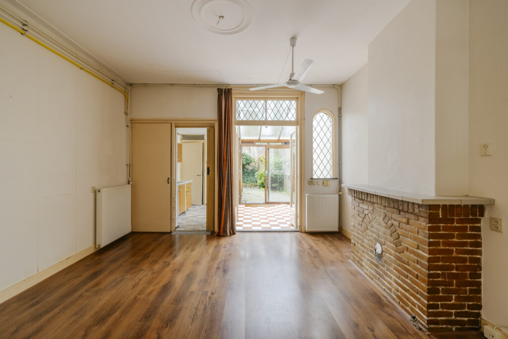 Empty room with wood floor and fireplace.