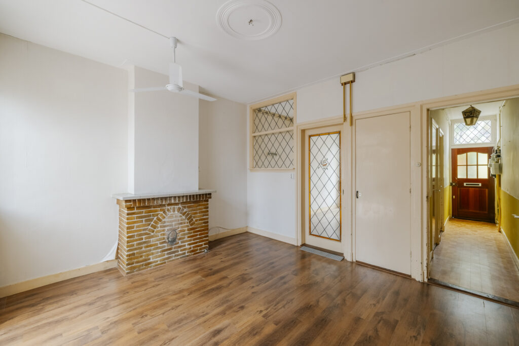 Empty room with wooden floor and brick fireplace