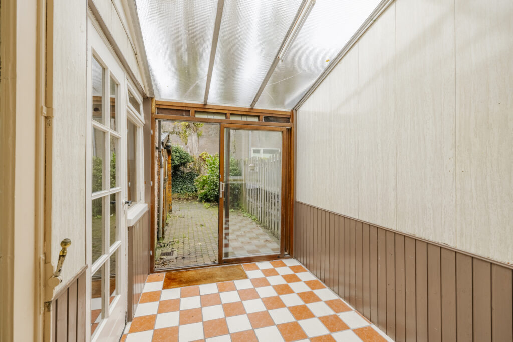Enclosed patio with sliding glass door and checkered floor.