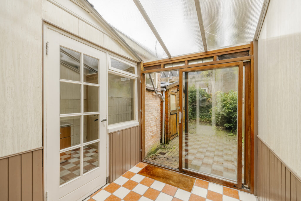 Enclosed porch with glass doors and tiled floor.