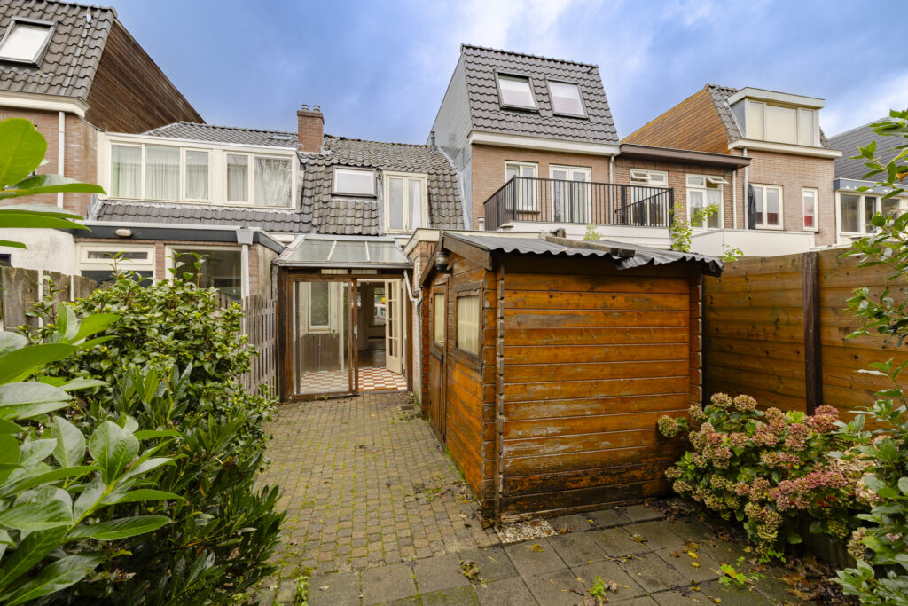 Backyard with wooden shed and garden.