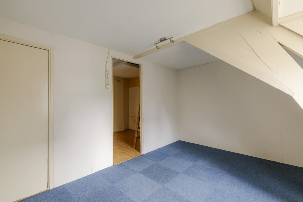 Empty room with blue carpet and white walls.