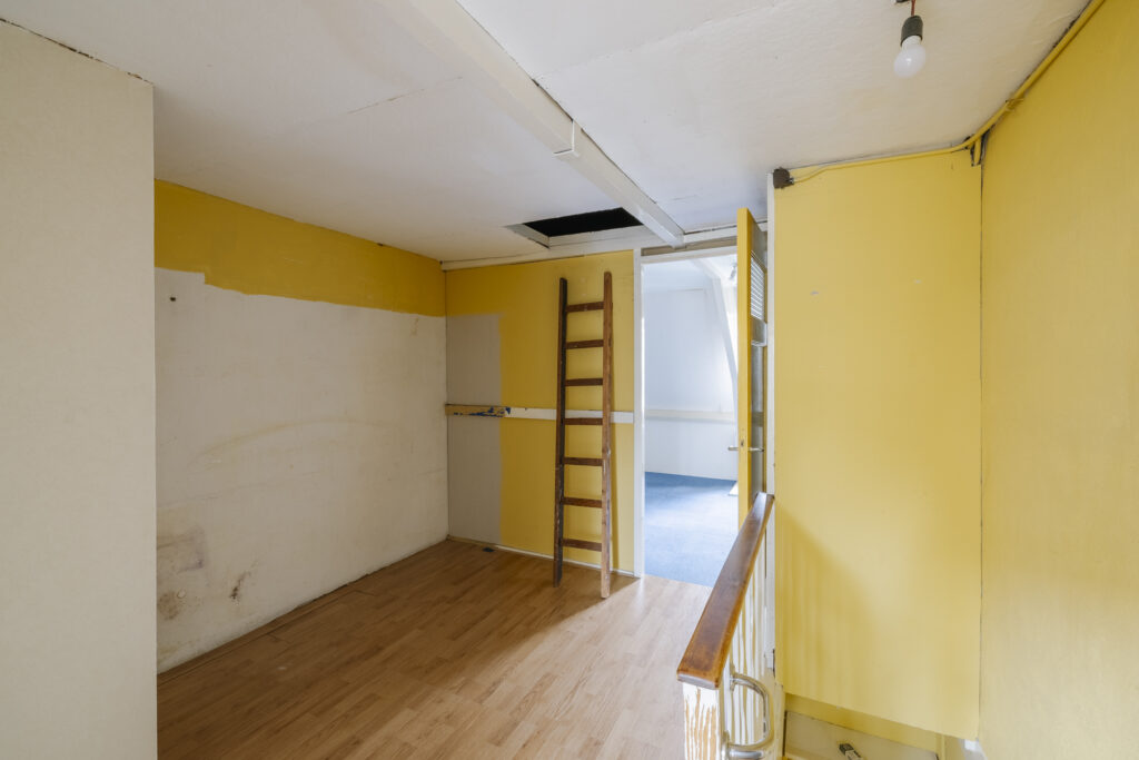 Small yellow room with wooden ladder