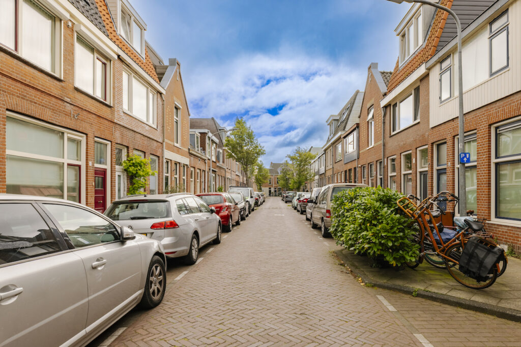 Quiet residential street with parked cars and bicycles.