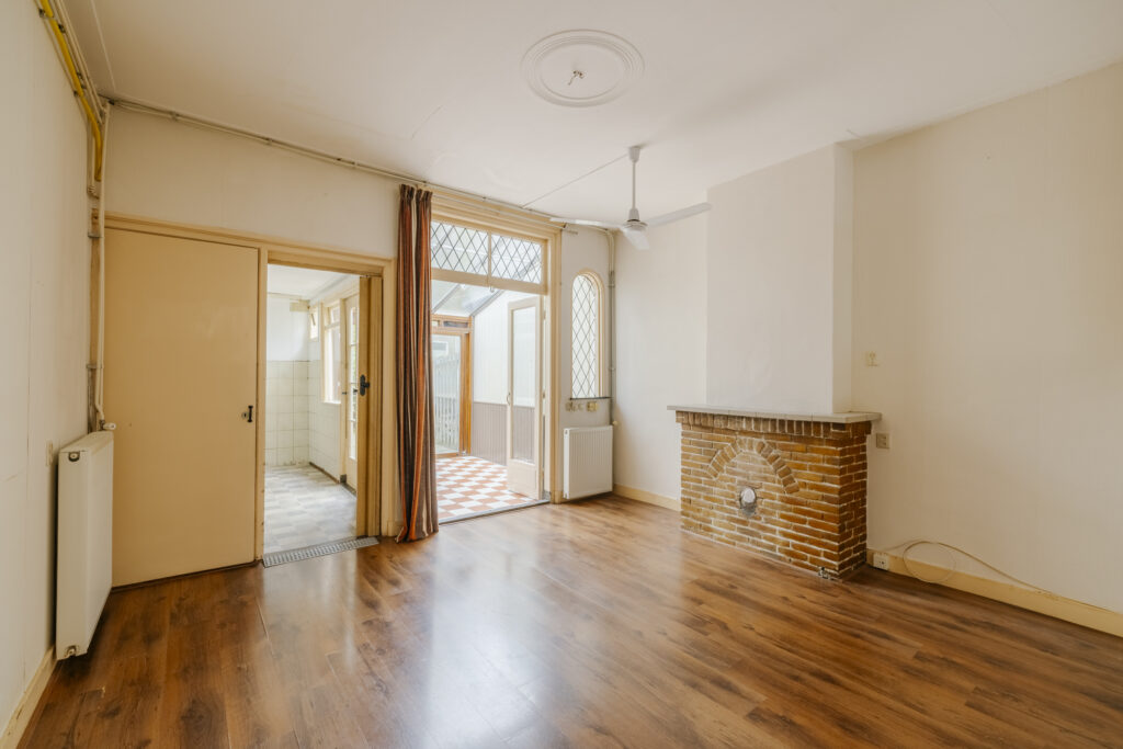 Empty room with wooden floor and fireplace