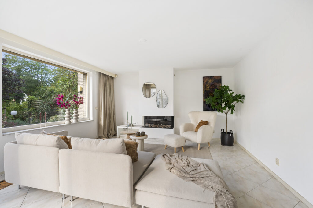 Modern living room with large window and plants.